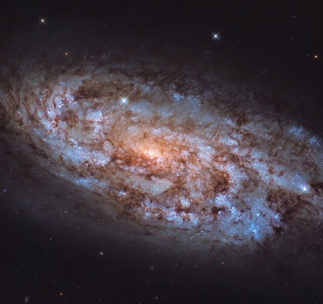 شکوه یک کهکشان مارپیچی ستاره فشان